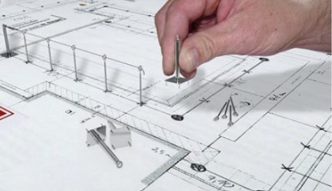 Main plaçant des points d’ancrage sur un plan de toiture pour la conception d’un système de sécurité antichute
