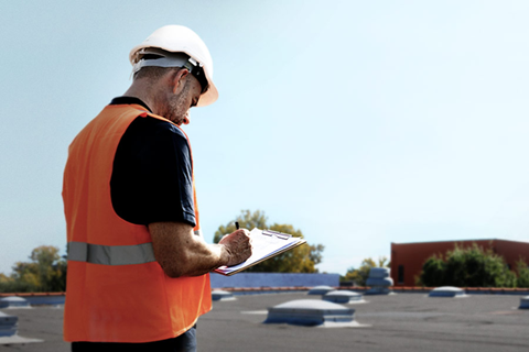 Expert réalisant un audit de sécurité sur une toiture plate